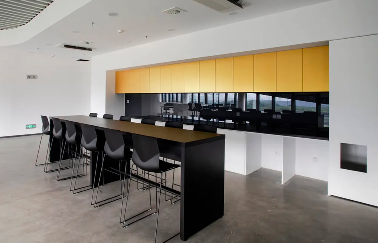 A black conference table with counter chairs in a modern office.