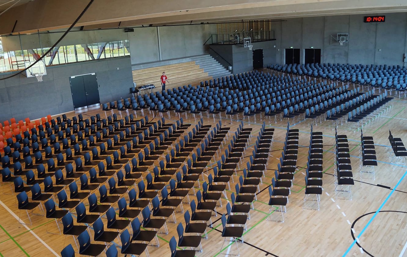 A large gymnasium with many rows of chairs.
