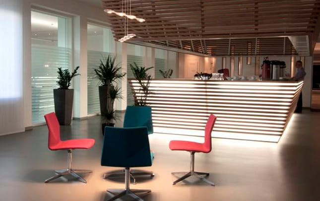 A modern office with colourful chairs and a desk.