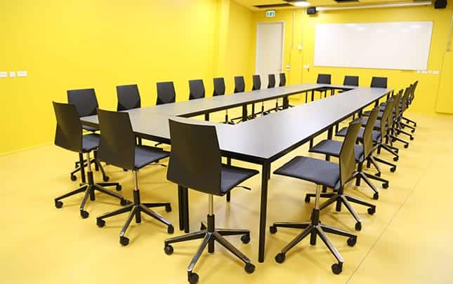 A conference table and office desk chairs in a conference room.