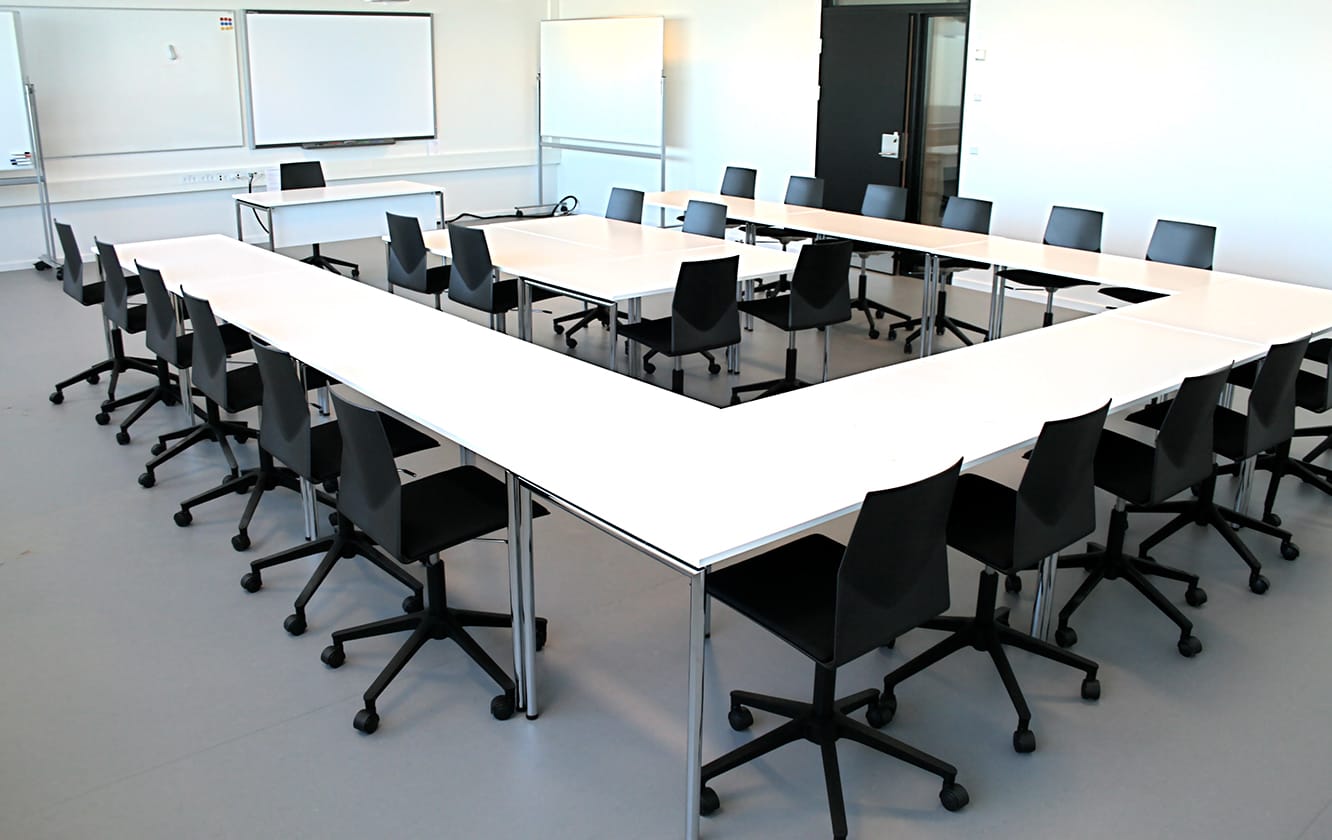 A conference table and office desk chairs in a conference room.