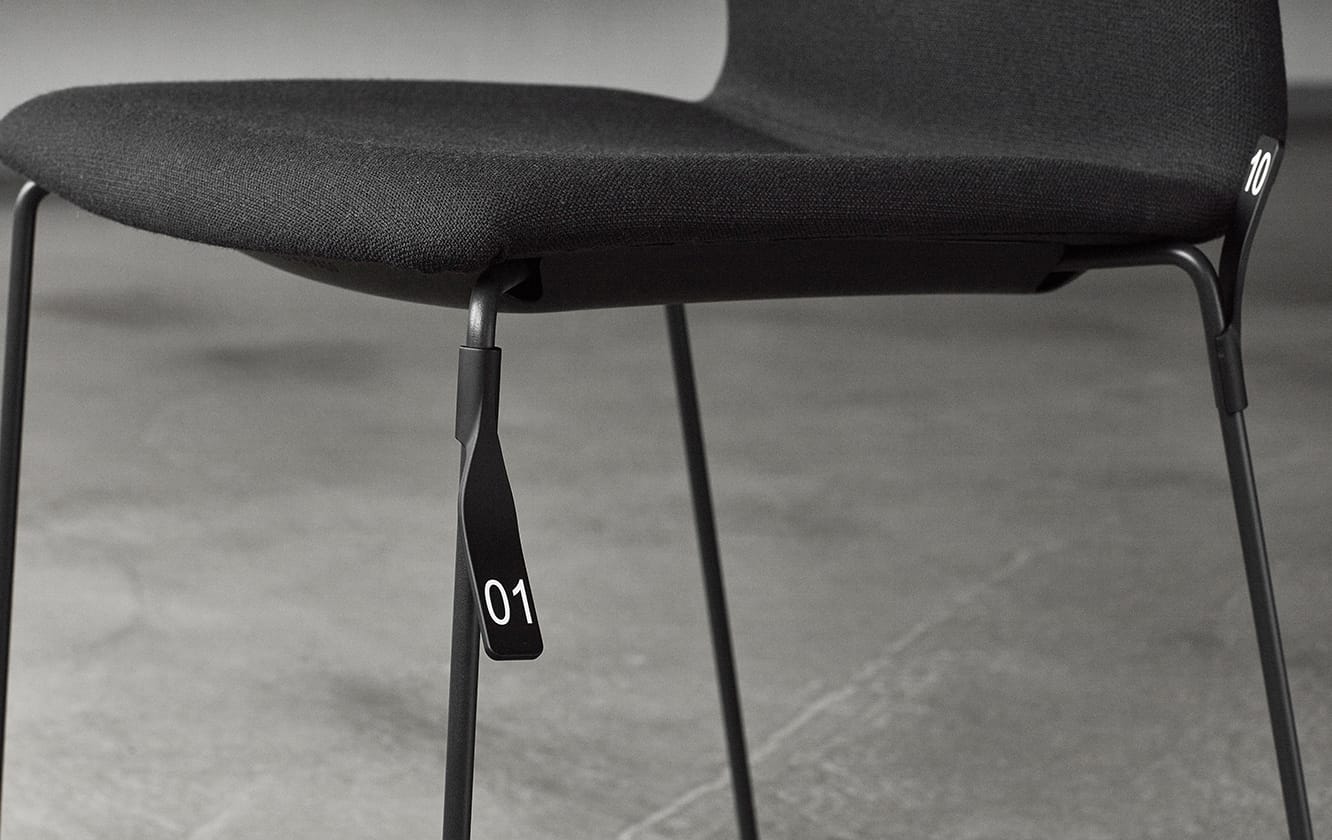 A black chair with a black seat and metal legs.
