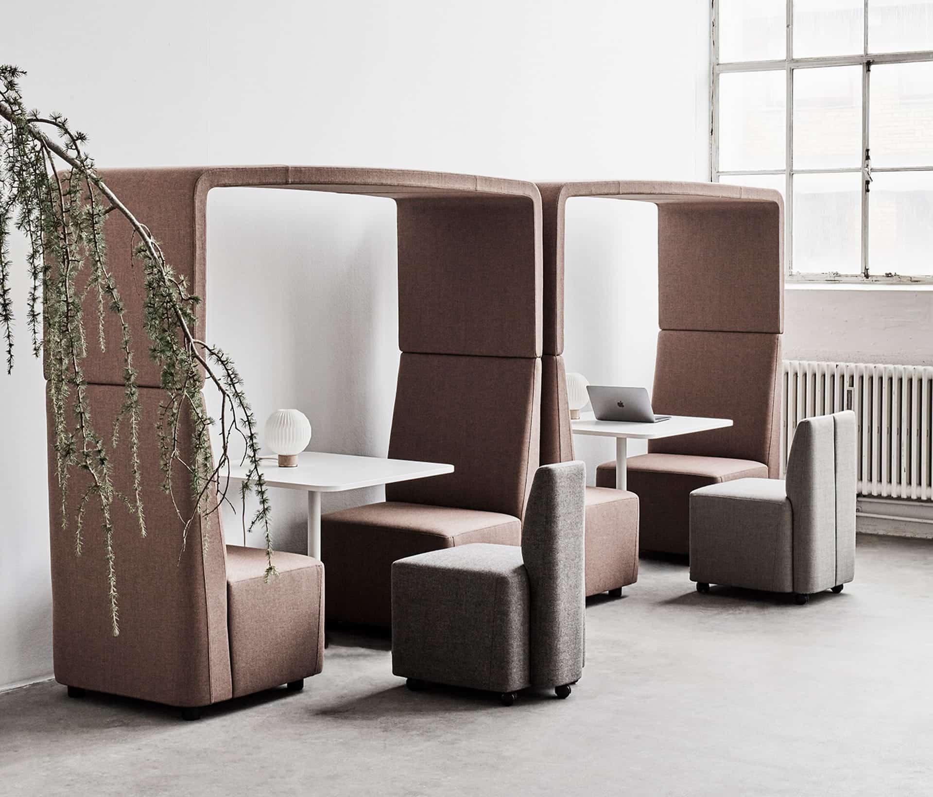 Two office work booths with white desks and lounge chairs