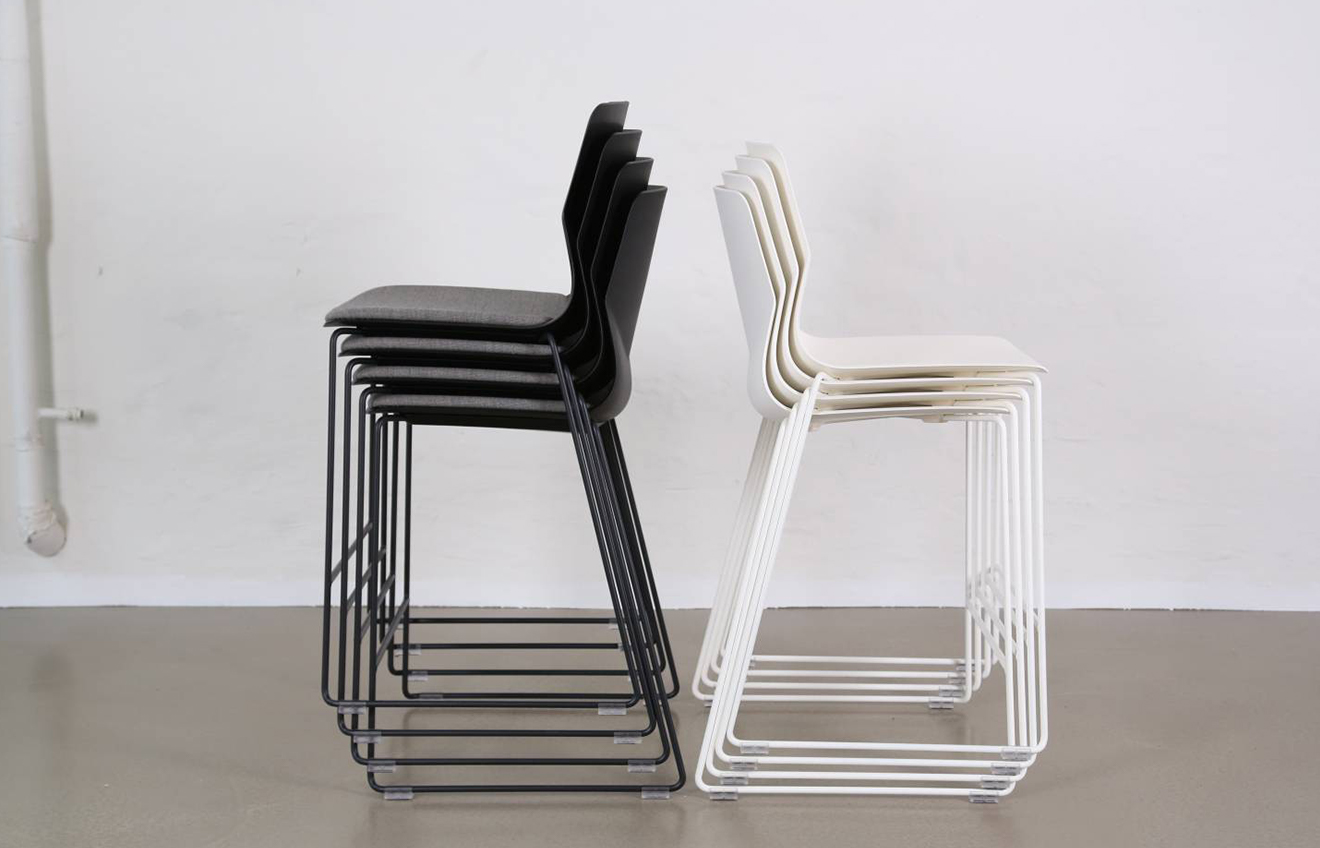 A pair of black and white counter chairs in a white room.
