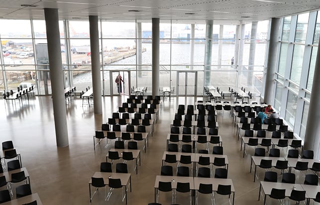 A large conference room with many tables and chairs.