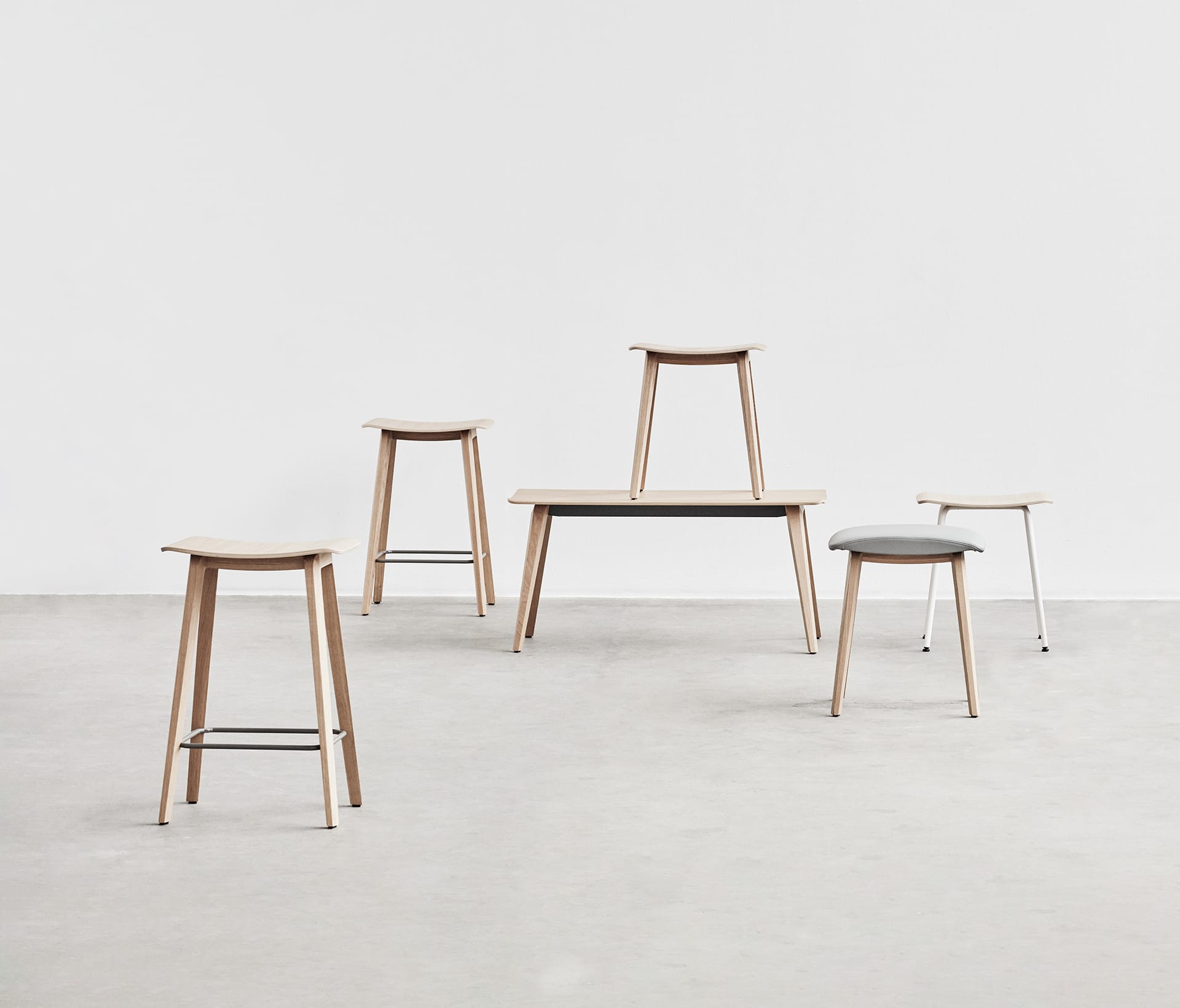 A collection of office stools in a white room.