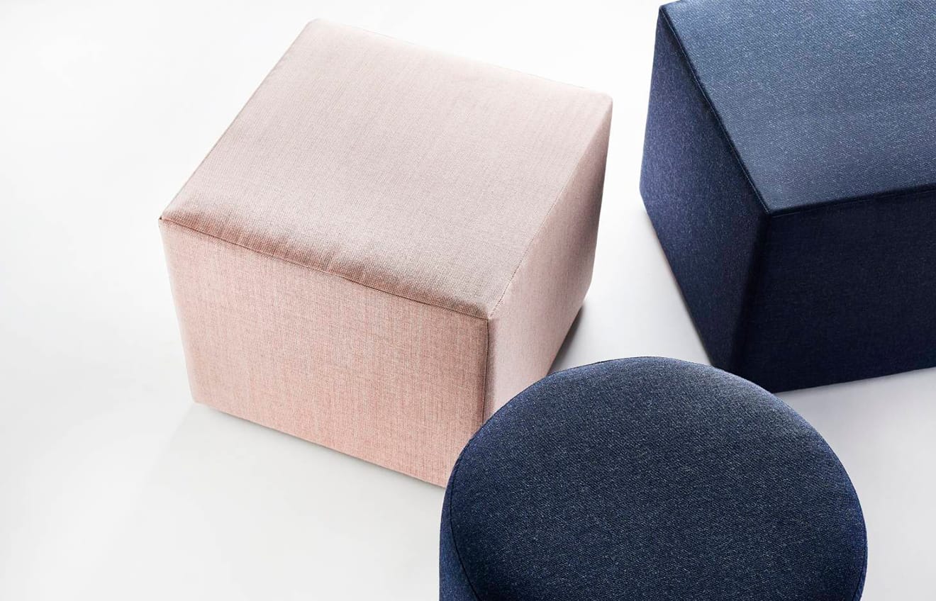 A pair of blue and pink ottomans on a white surface.