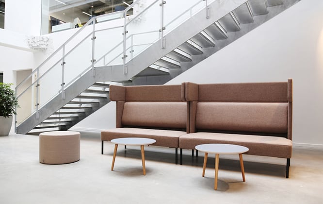 A modern office with a staircase and couches.