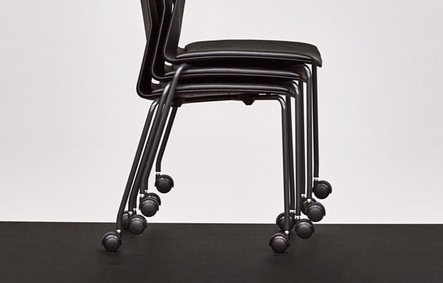 A black chair with wheels on a black background.