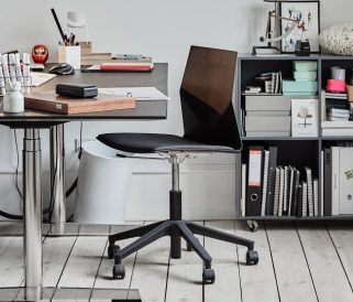 A desk with a black chair and books on it.