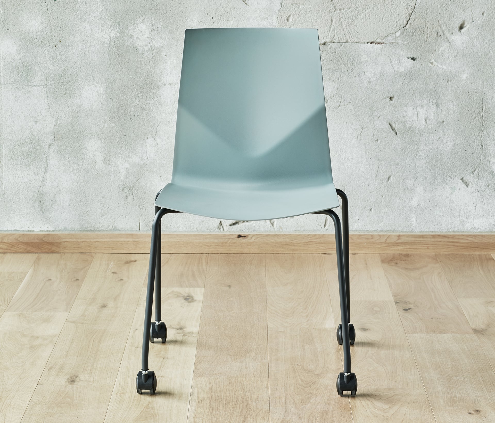 A chair with wheels in front of a wall.