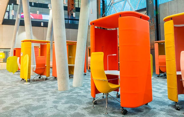 orange and yellow office work booths in an antrium