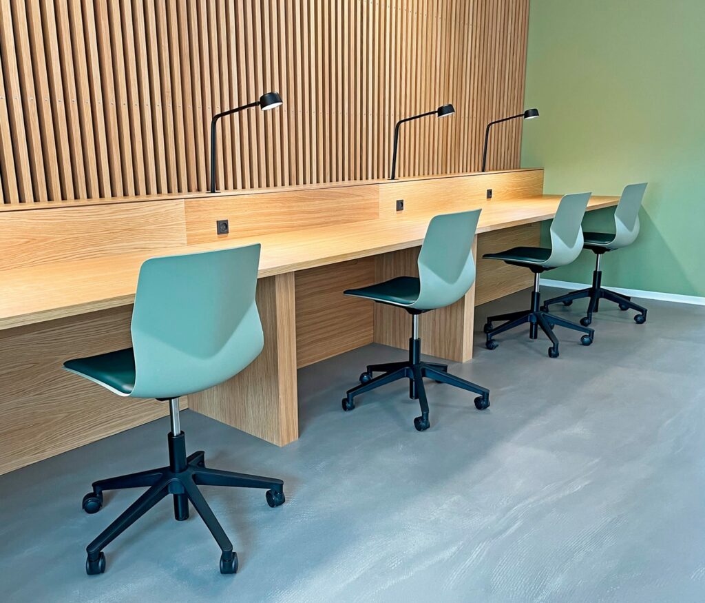 Study booths, desk workstations and chairs in an office.