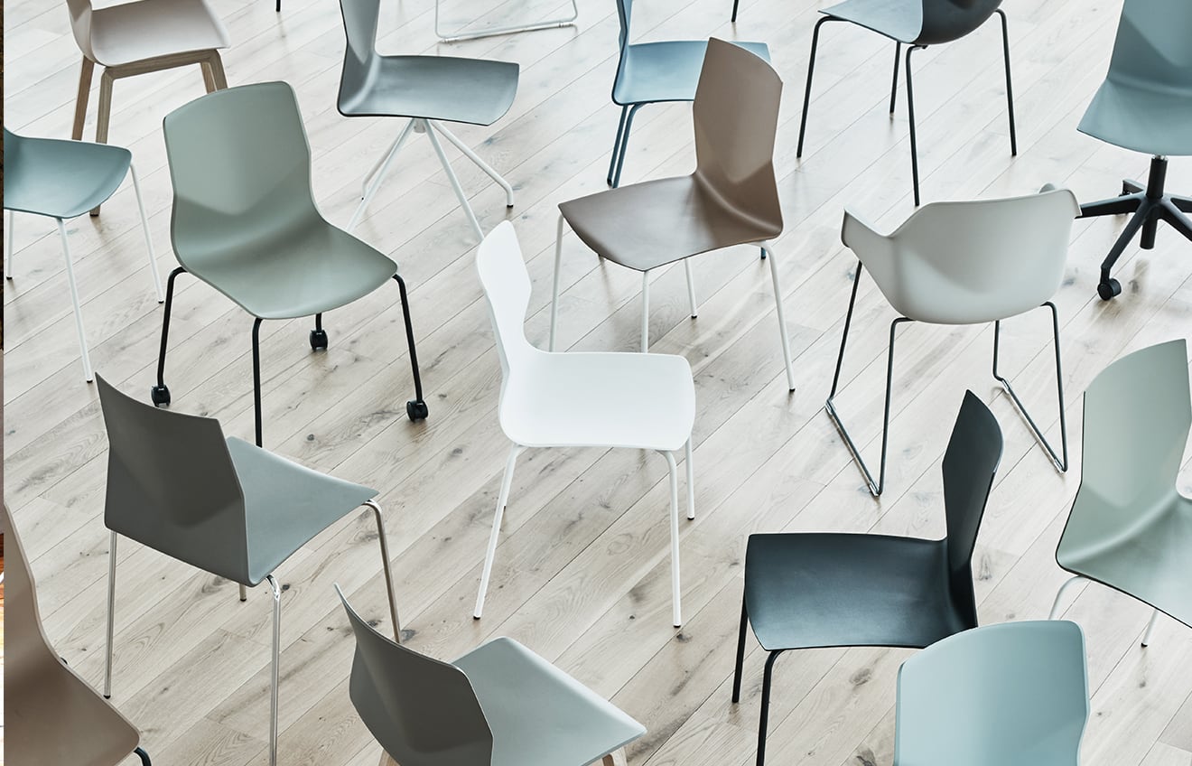 A group of different coloured chairs in a room.