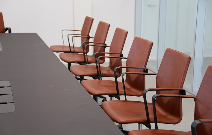 A row of brown leather chairs in a conference room.