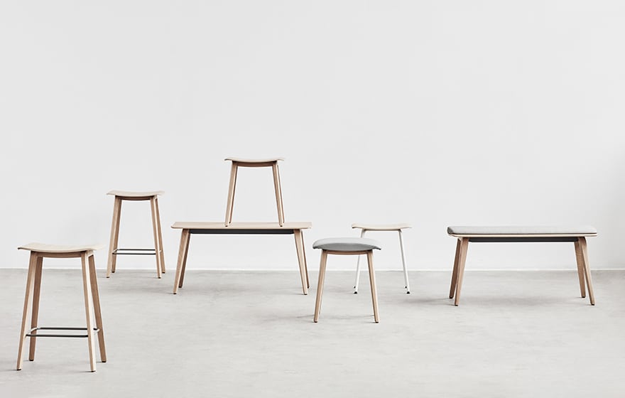 A group of wooden office stools in a white room.