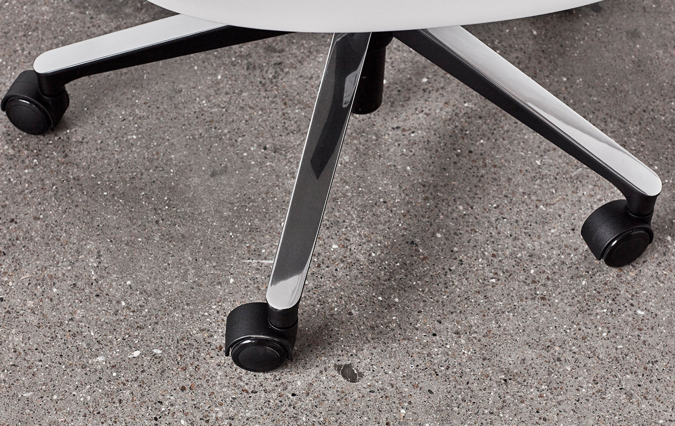 Detail of an black office chair's wheels on the floor.