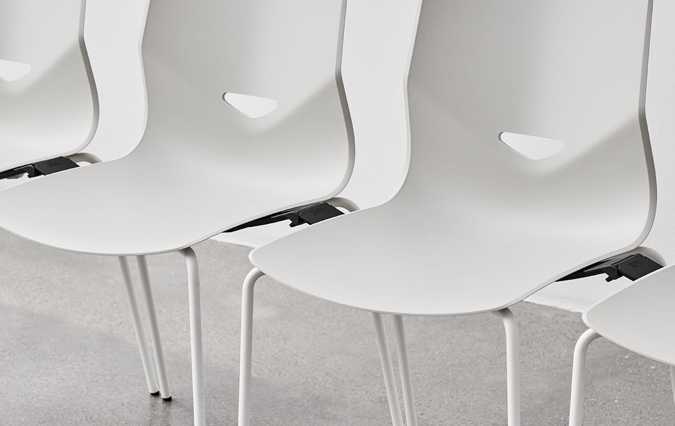 Detail of attachment between a row of white office desk chairs