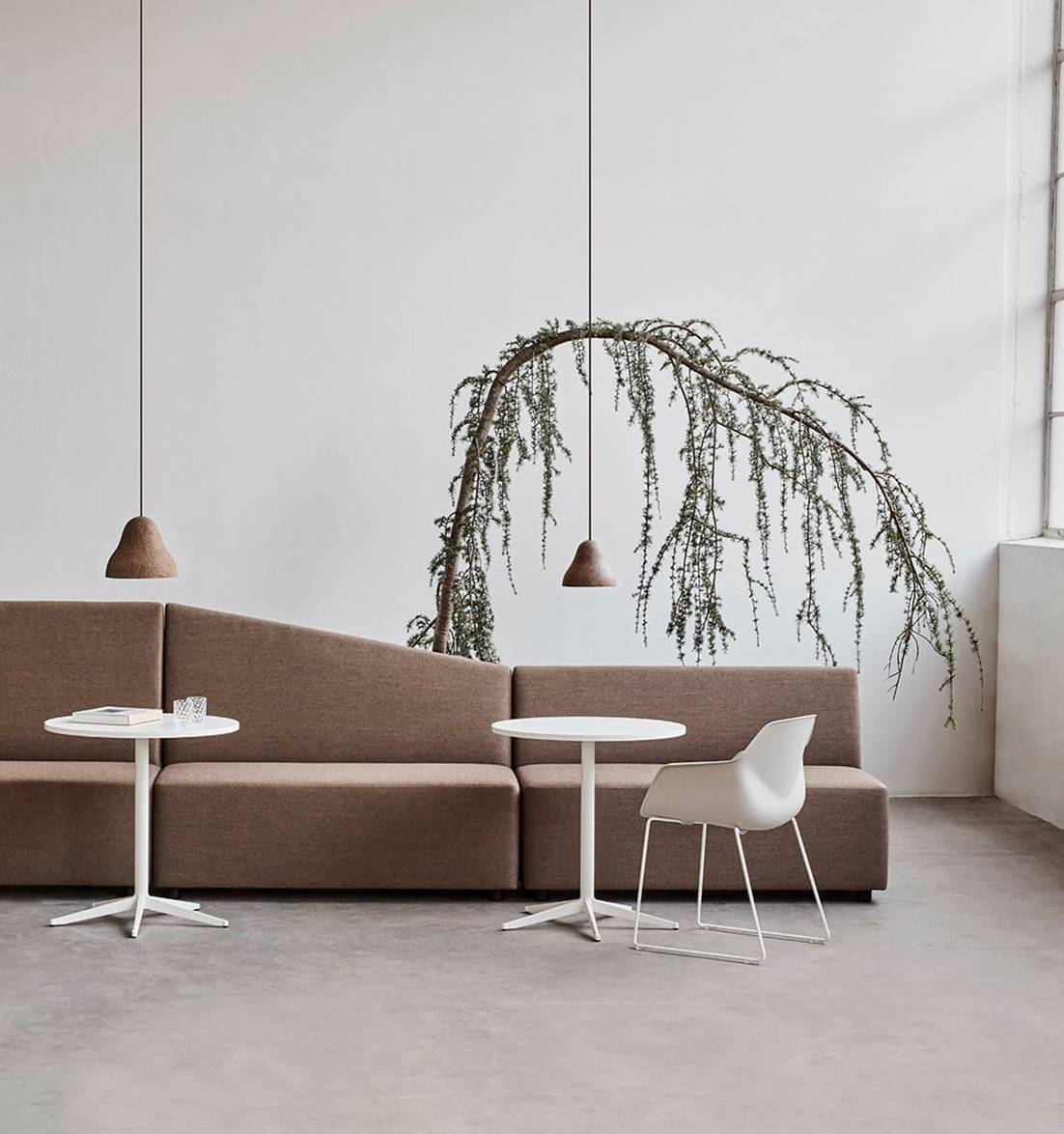 Modular seating, table and office desk chairs in a room with a tree.