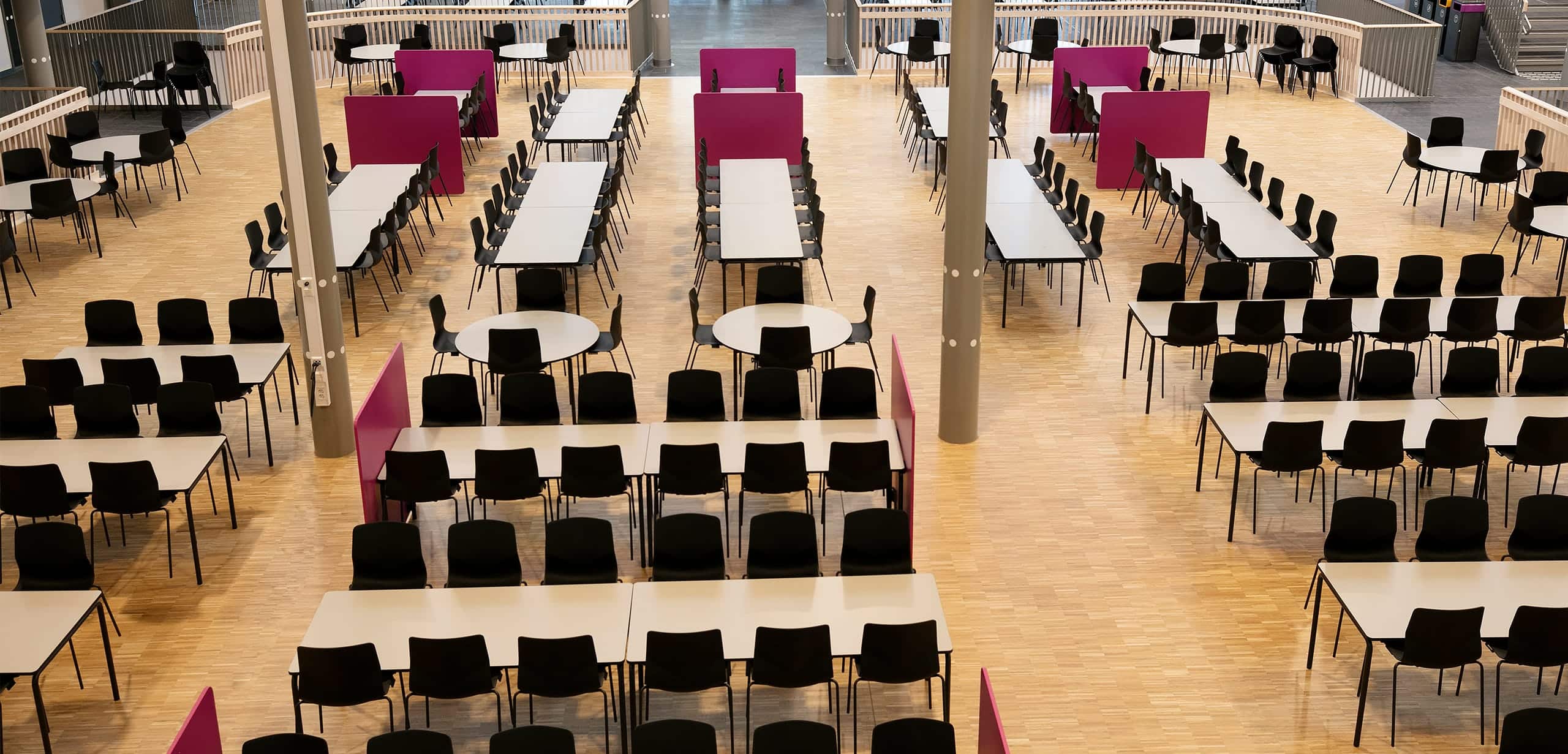 A large hall with office tables and chairs.