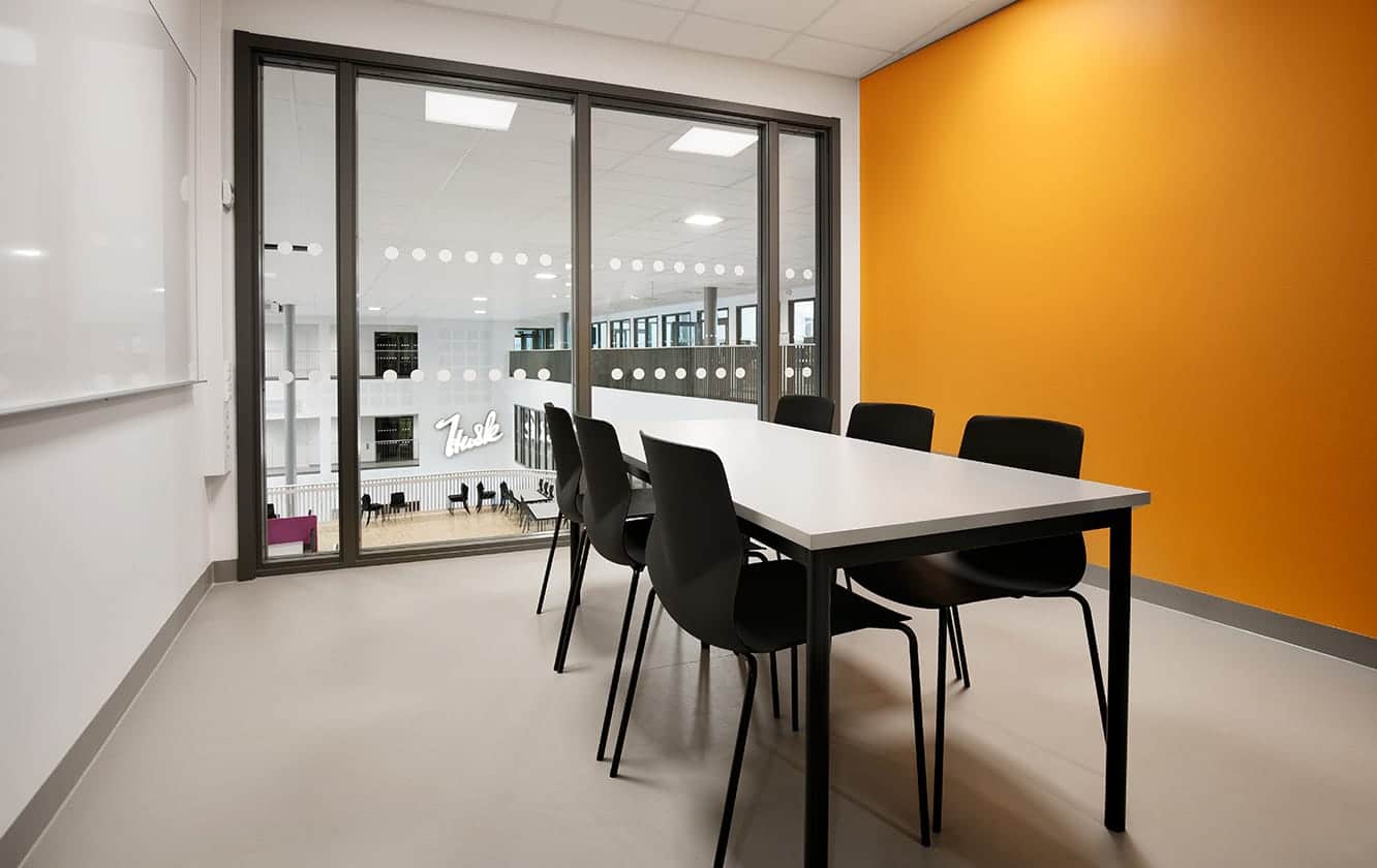 A conference room with a large conference table and office desk chairs.