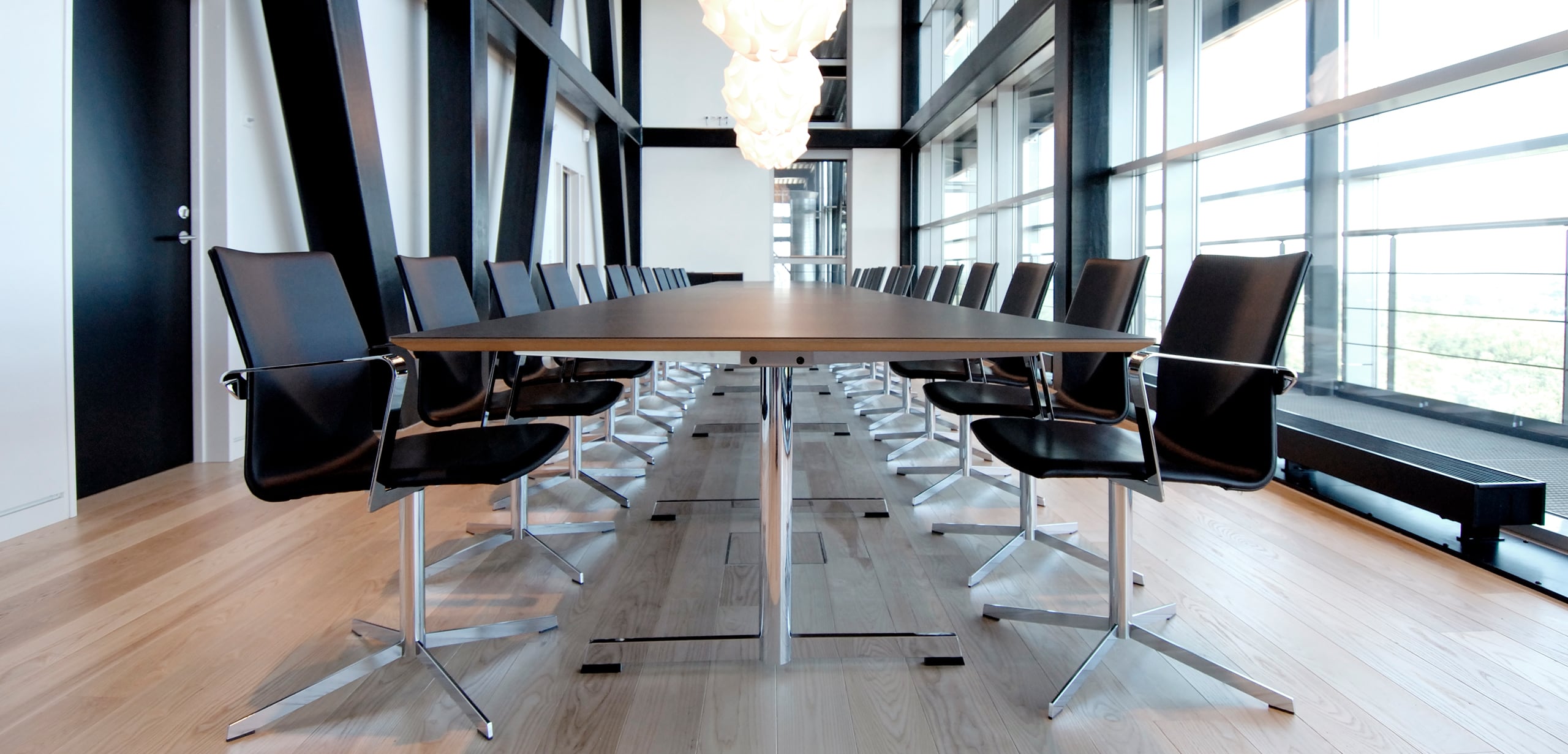 A conference table with black chairs in a large room.