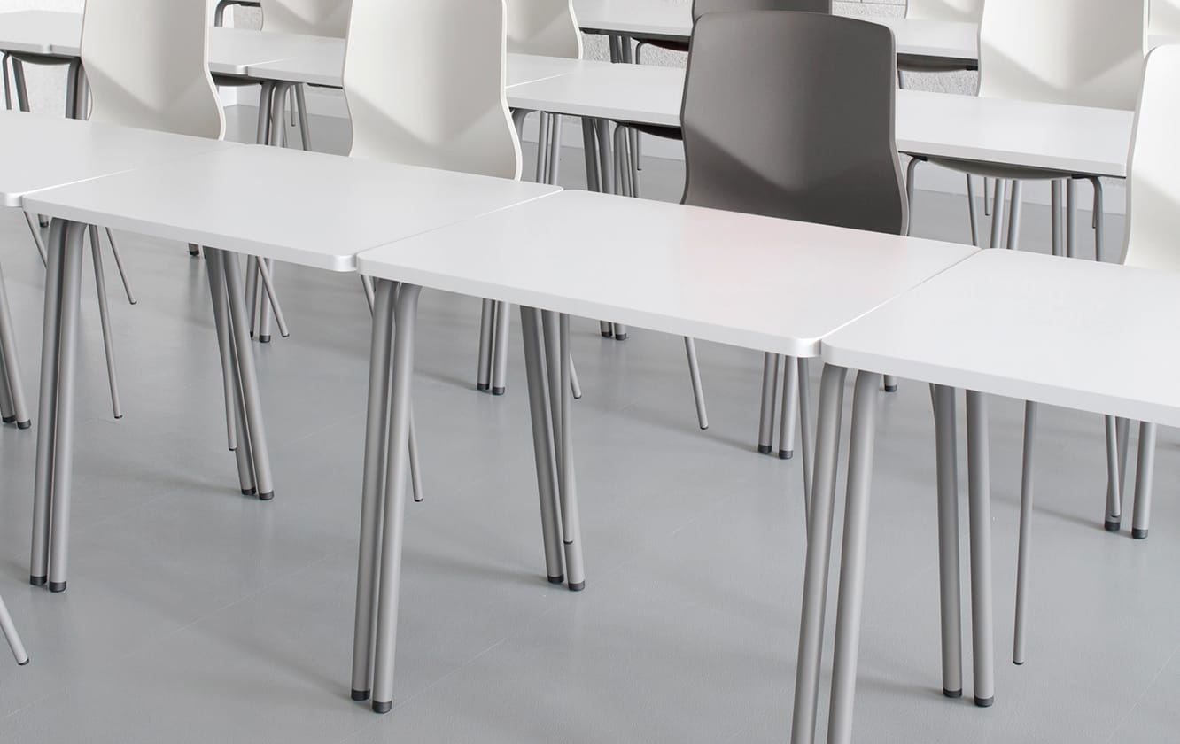 A group of office desk chairs and office tables in a lecture hall