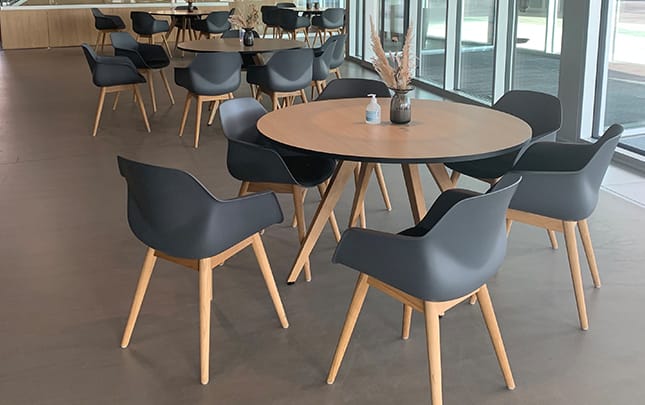 A round table and chairs in a cafeteria.