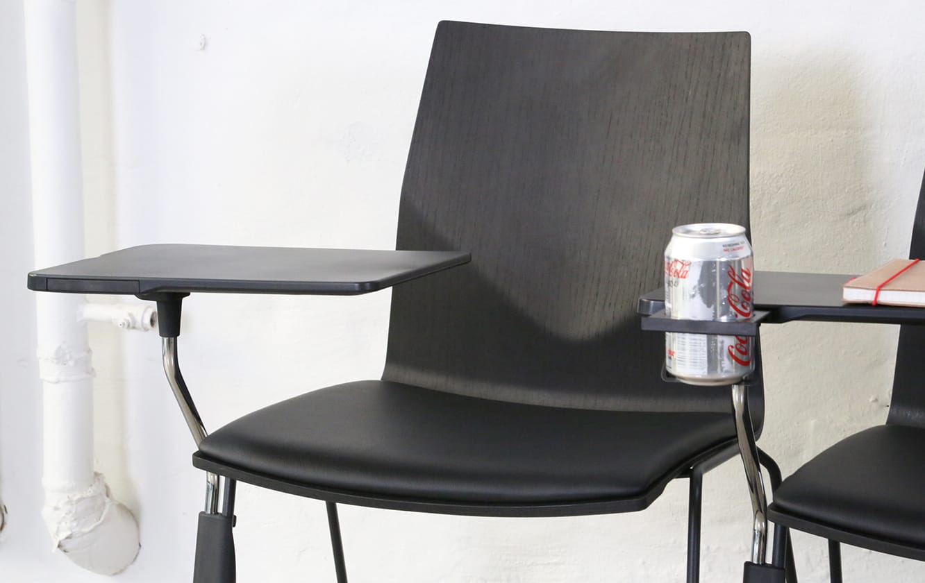 Two black chairs with desk attached with a can on them.