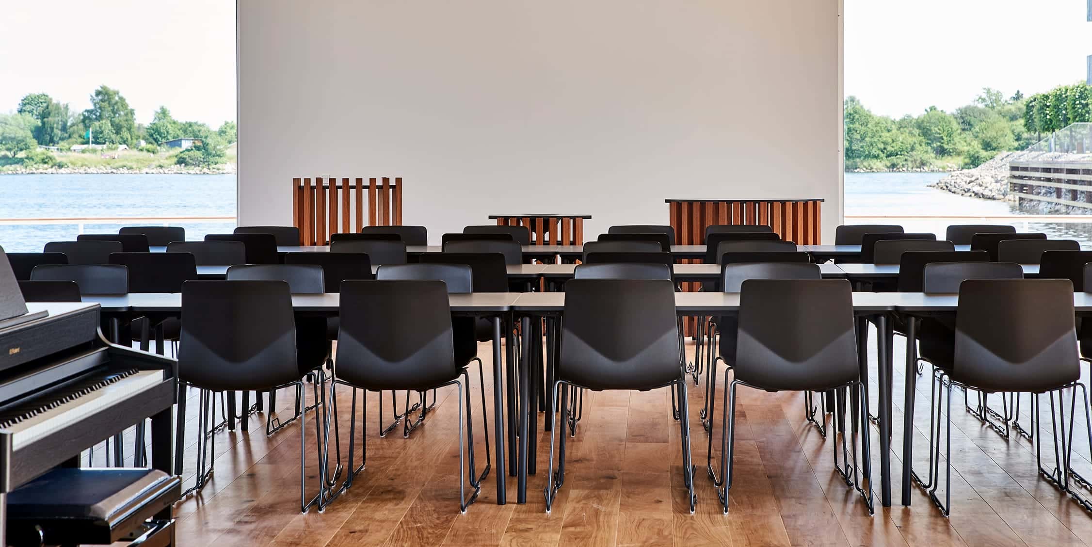 A large room with black office desk chairs