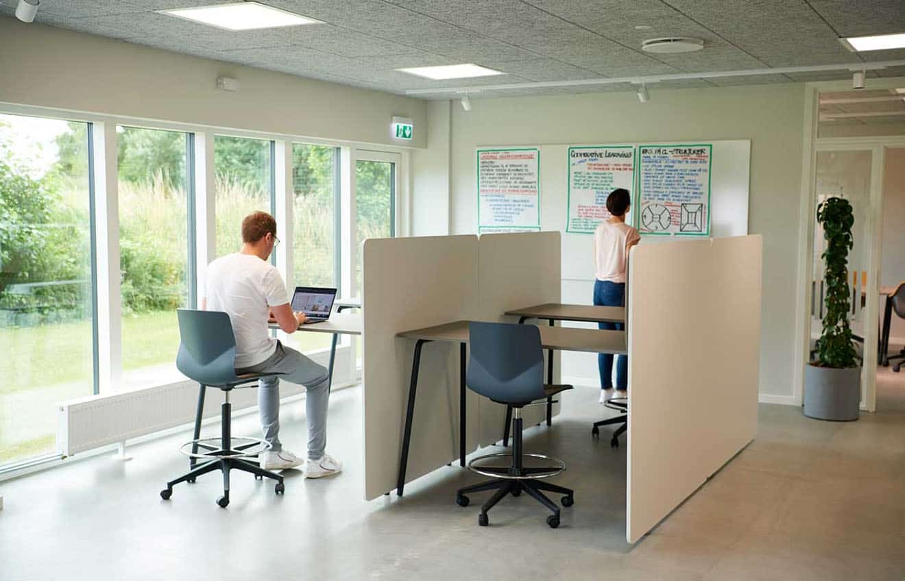 Two people sitting at study booths in an office.