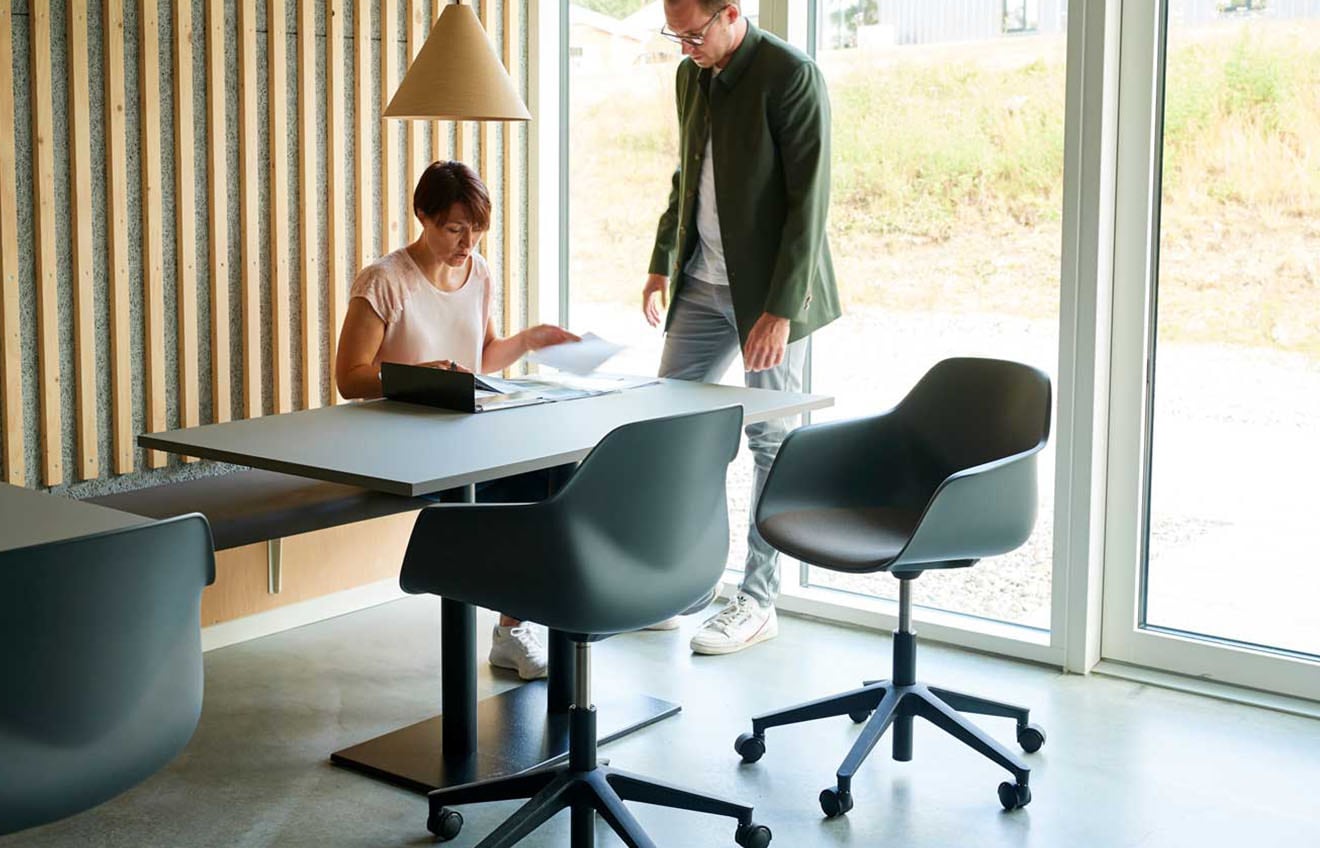 Two people sitting at a table in an office.
