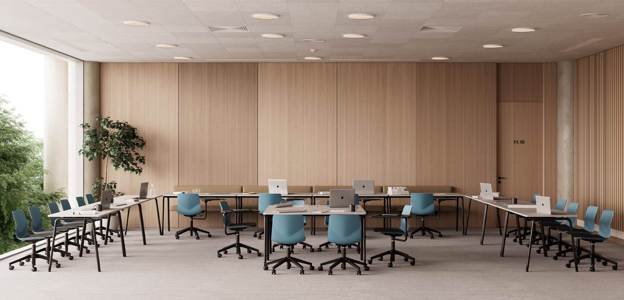 A room with office tables and office desk chairs and a large window.