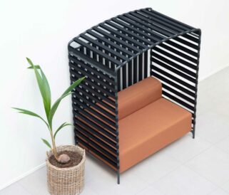 A black slatted bench next to a potted plant.