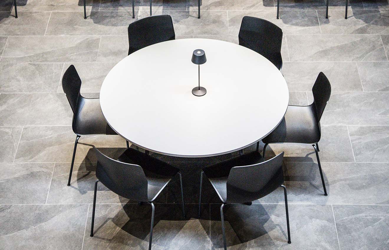 A round table with black chairs in a conference room.