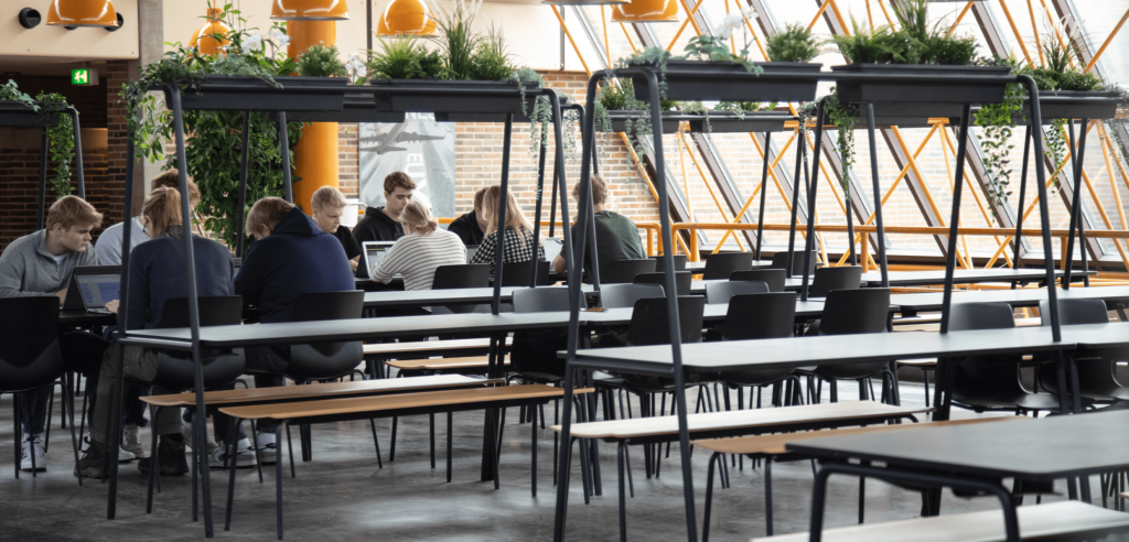 The interior of a canteen with canteen furniture, community tables and chairs.