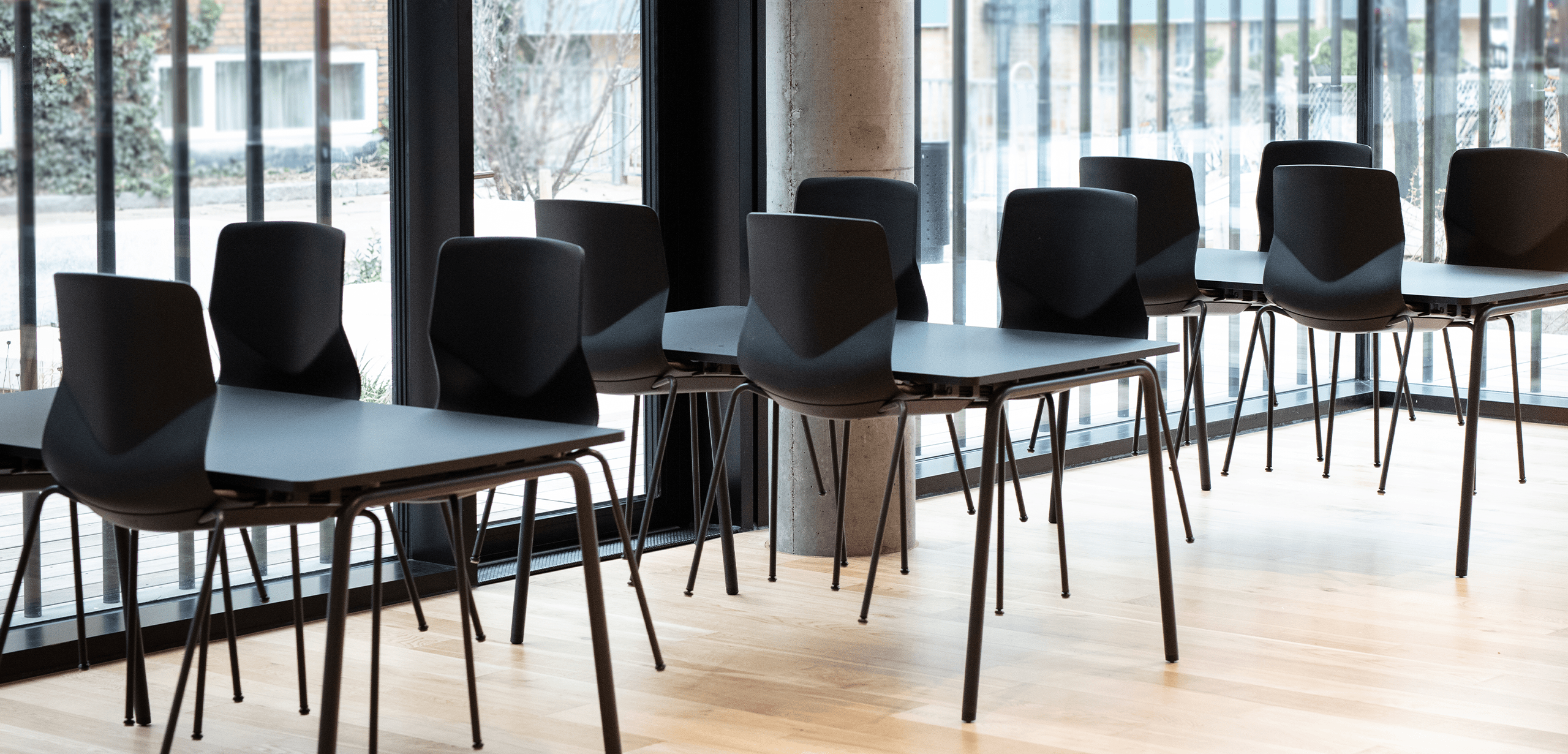 A row of black chairs and tables in a room.