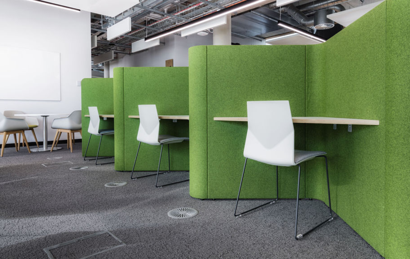 An office with green study booths with walls and chairs in the University of Sheffield
