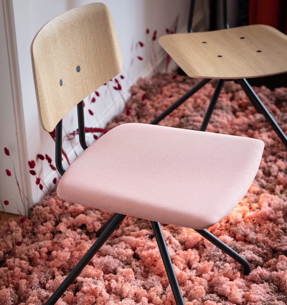 Two pink Share office desk chairs on a rug.