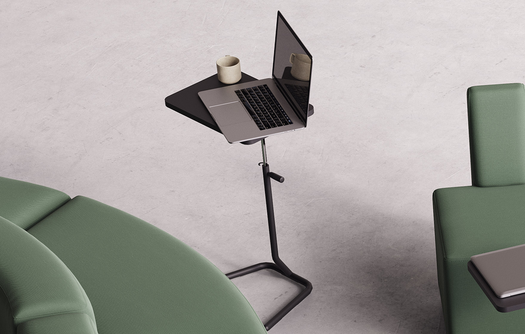 A laptop on an Y-table adjustable height work table next to a green couch.