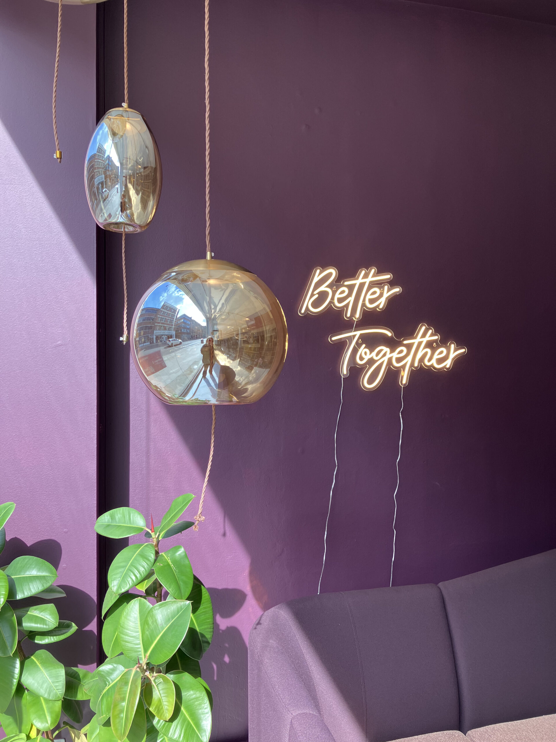 Brand Identity at our London Showroom. A room with a purple couch and a neon sign that says better together.