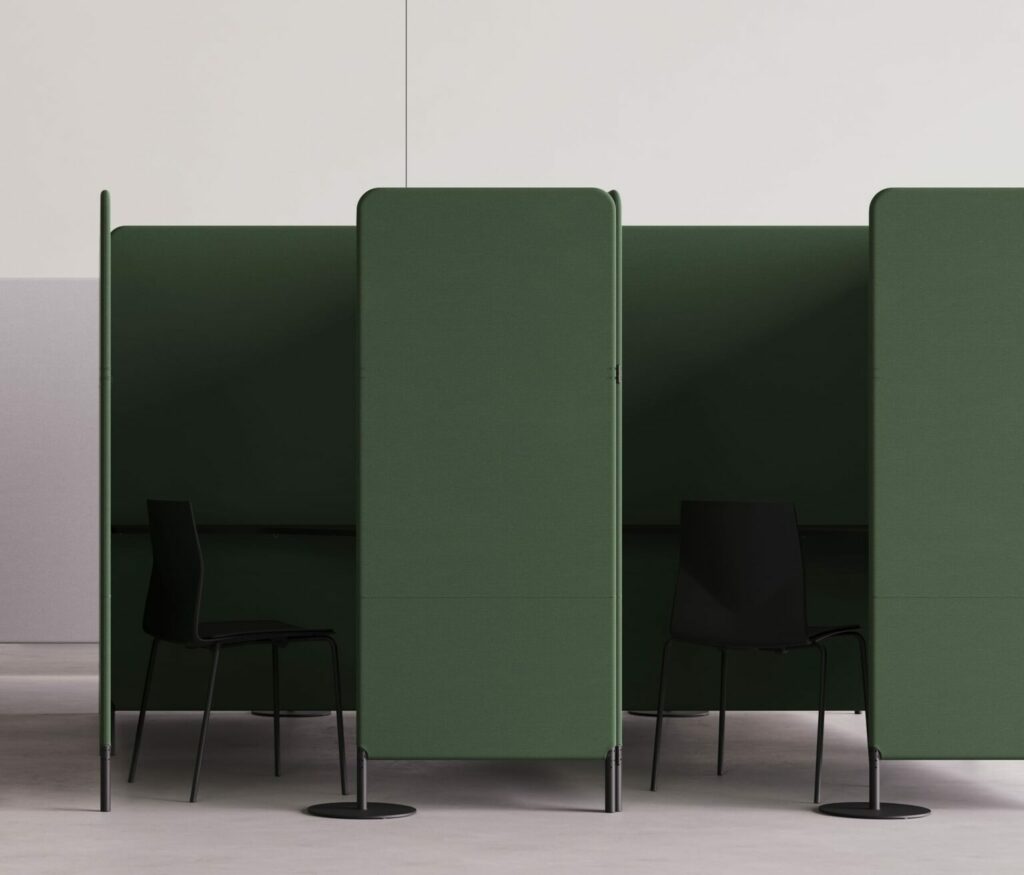 A green FourPeople office work booth and office cubicle with two chairs and a desk.