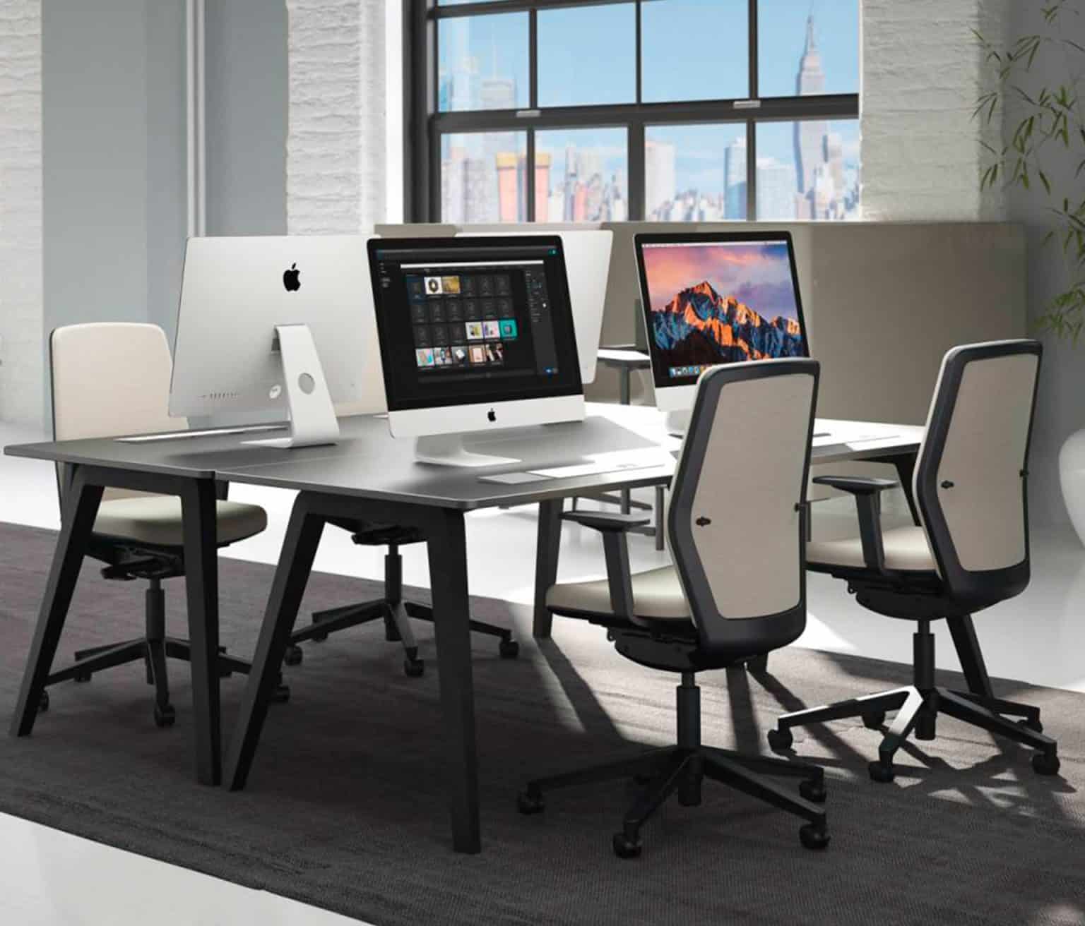 A computer desk with two monitors and two chairs.