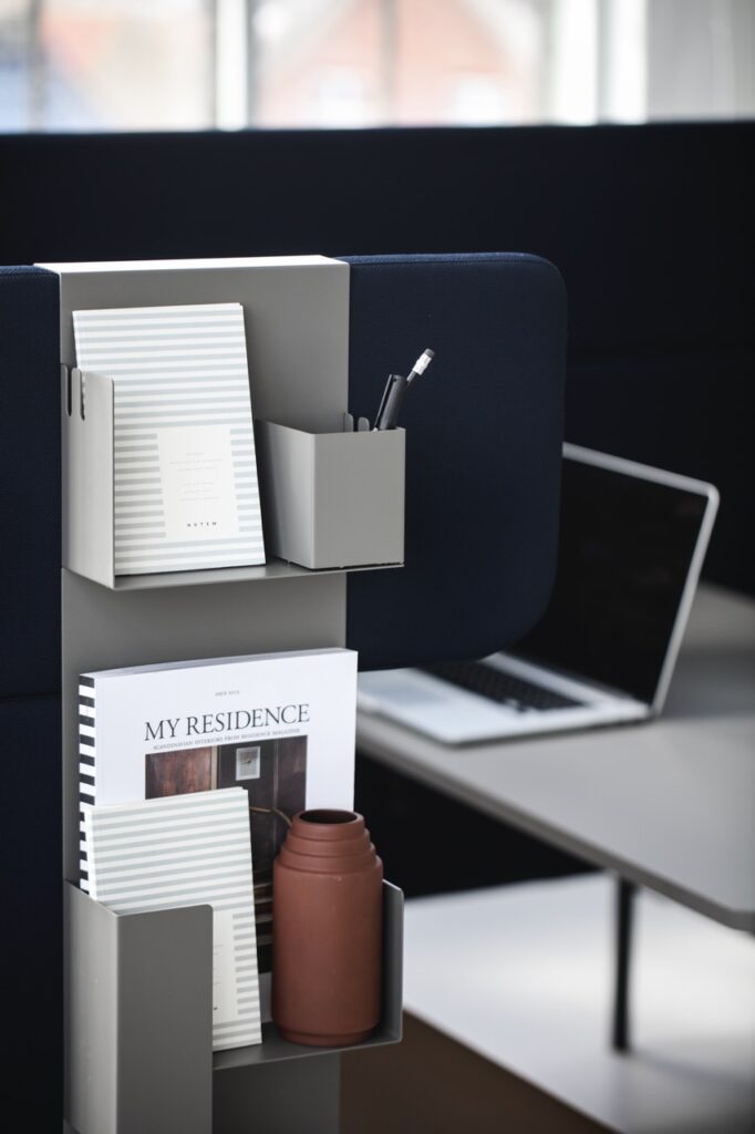 FourUs® Booth with an accessory attached, holding books, pens and other workspace essentials.