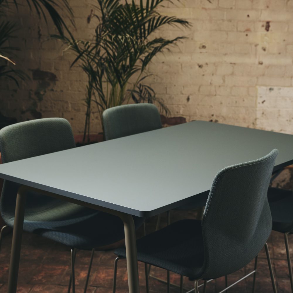 A dark green FourReal 90 table with four FourSure 44 upholstered chairs