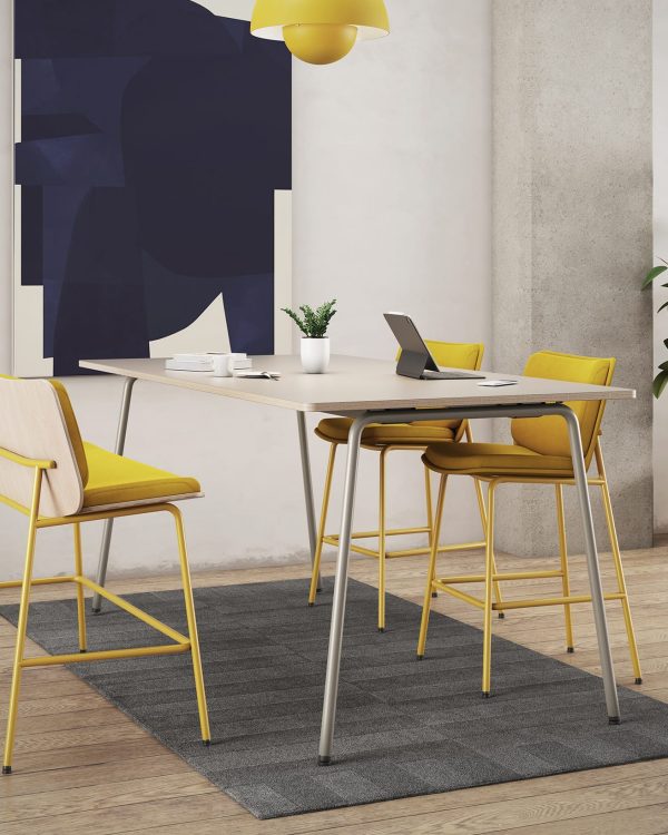 A room with a yellow standing height tables and counter chairs