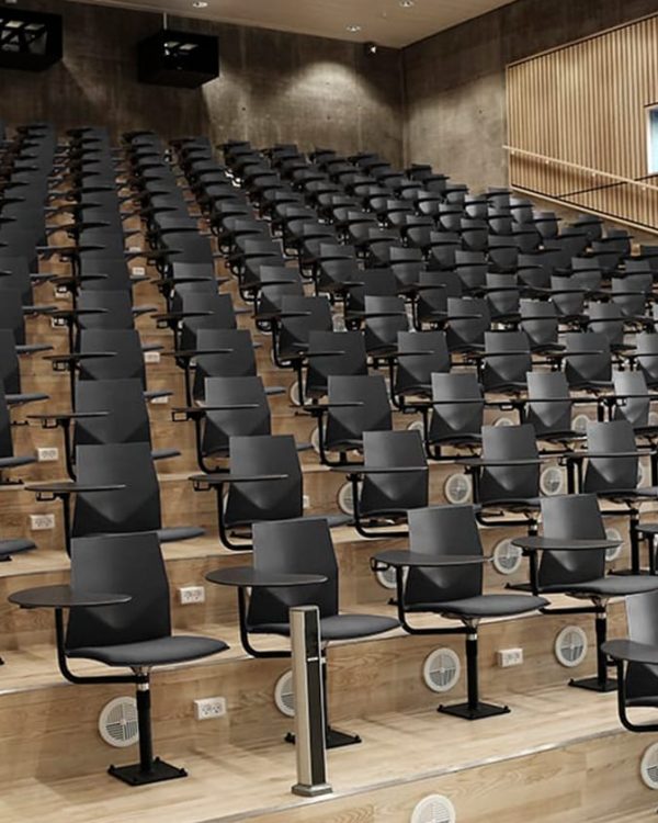 A large auditorium with rows of black chairs.