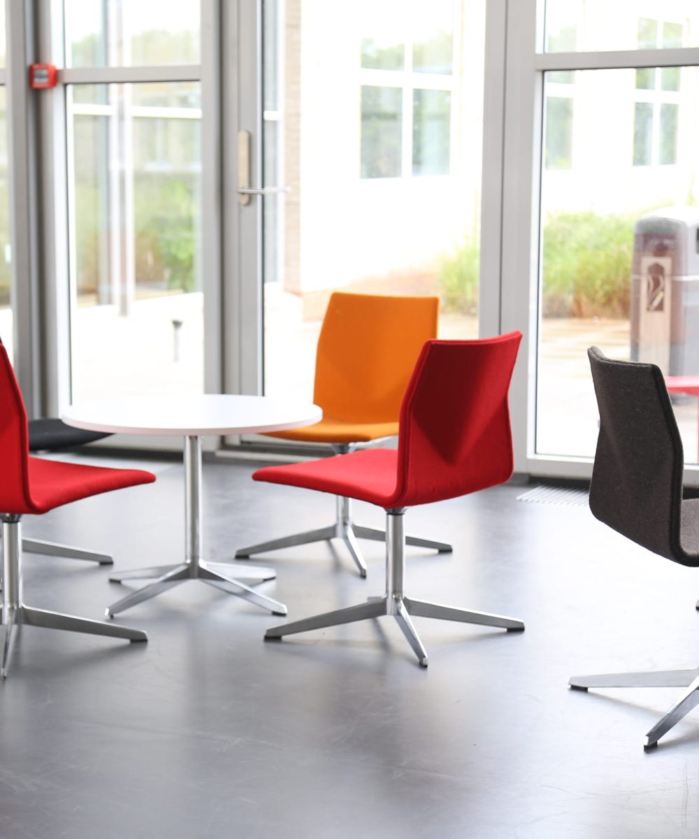 A group of colourful chairs in a conference room.