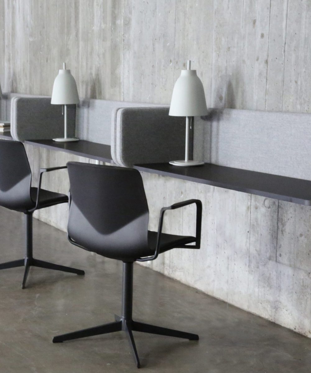 A chair and three wall mounted desk workstations