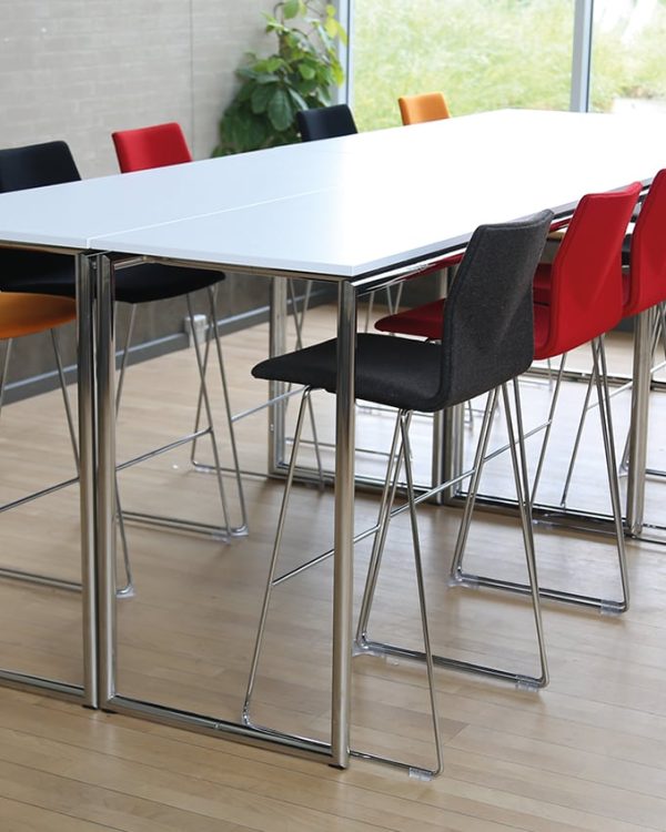 A white conference standing height table with counter chairs around it.